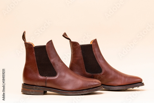 Footwear ideas. Closeup of Pair of Classic Leather Chealsea Boots As Still Life Concepts Placed Close to One Another Over Beige