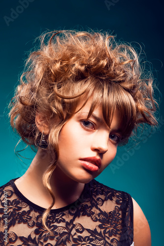 Young Beauty Girl Demonstrating Short Curly Hairstyle as Fashion, Cosmetics and Makeup Concept Over Green Background.