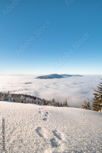 Mountainsides of the Beskydy region in the Czech Republic are sinking into a thick white inversion rising from the cities. Winter fairytale scenery in central Europe