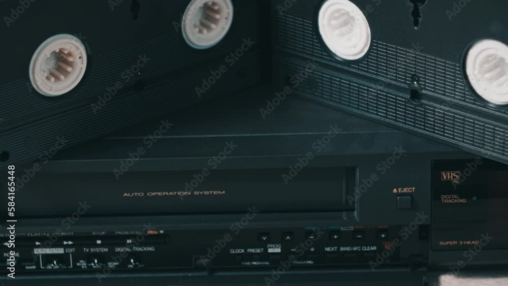 Eject VHS tape cassette from VCR player. Male hand pushes a button and