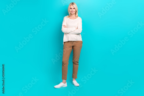 Full length photo of shiny adorable woman wear white shirt arms crossed smiling isolated turquoise color background