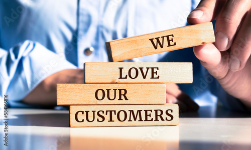Foto Close up on businessman holding a wooden block with We Love Our Customers mess