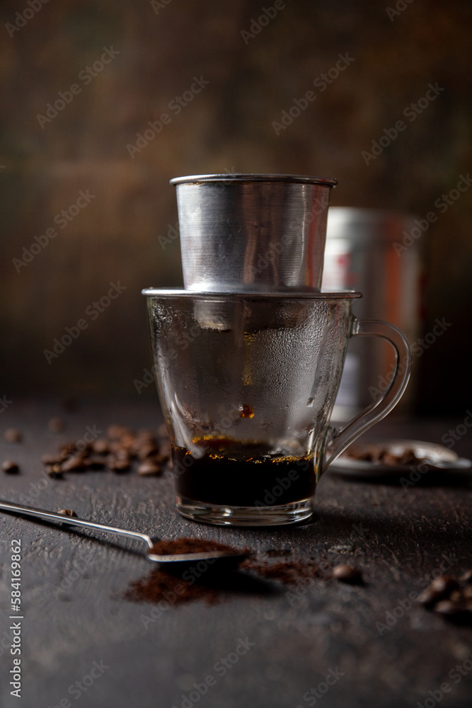 Preparation of Vietnamese coffe with aluminum cofe filer on dark background Preparation of Vietnamese coffe with aluminum cofe filer on dark background