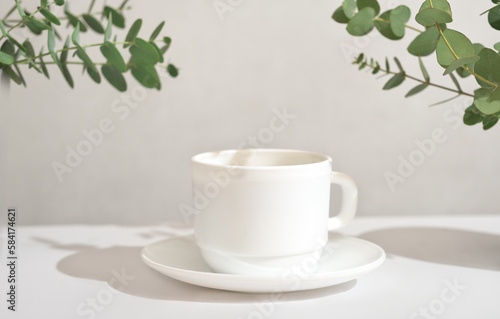 espresso coffee in a white classic cup, good morning, green leaves around a cup