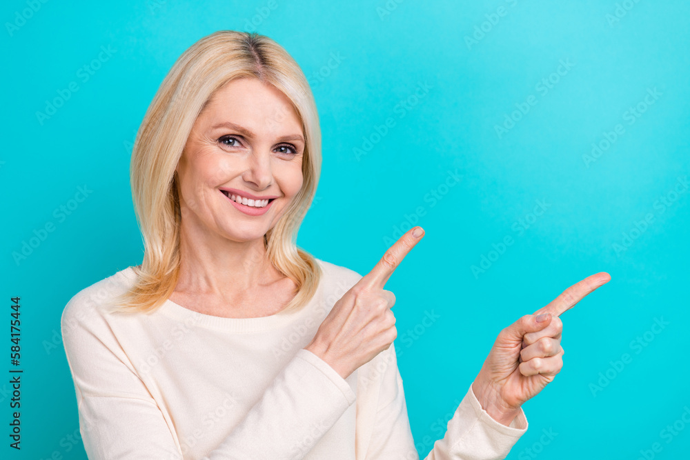 Photo of positive pretty lady dressed white shirt pointing two fingers empty space isolated teal color background Photo of positive pretty lady dressed white shirt pointing two fingers empty space isolated teal color background