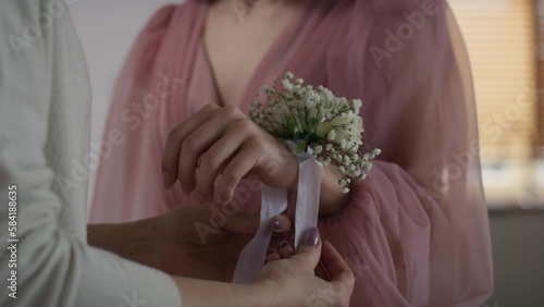 Unrecognizable  woman applying flower corsage on girl's wrist before prom. Shot with RED helium camera in 8K.     