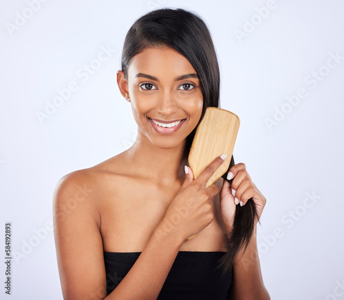 Woman, portrait smile and brush for grooming, haircare salon or keratin treatment against a white studio background. Happy isolated female beauty model smiling and brushing straight long hairstyle