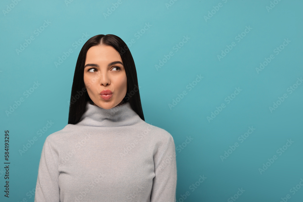 Beautiful young woman blowing kiss on light blue background. Space for text Beautiful young woman blowing kiss on light blue background. Space for text