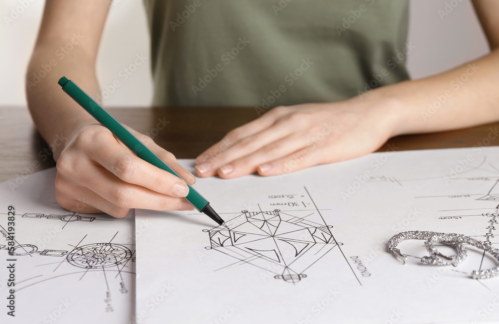Jeweler drawing sketch of diamond on paper at table, closeup Jeweler drawing sketch of diamond on paper at table, closeup