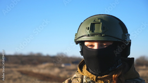 Happy military woman in helmet and balaclava fooling around around on camera. Female ukrainian army soldier showing positive emotion during war between Ukraine and russia. Faith in victory concept © olehslepchenko