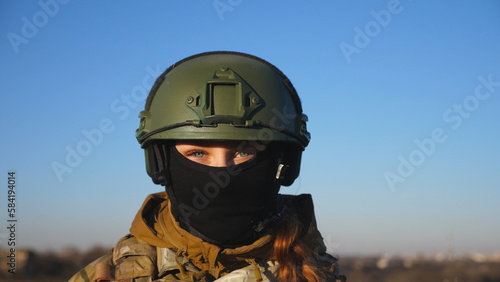 Happy military woman in helmet and balaclava fooling around around on camera. Female ukrainian army soldier showing positive emotion during war between Ukraine and russia. Faith in victory concept © olehslepchenko