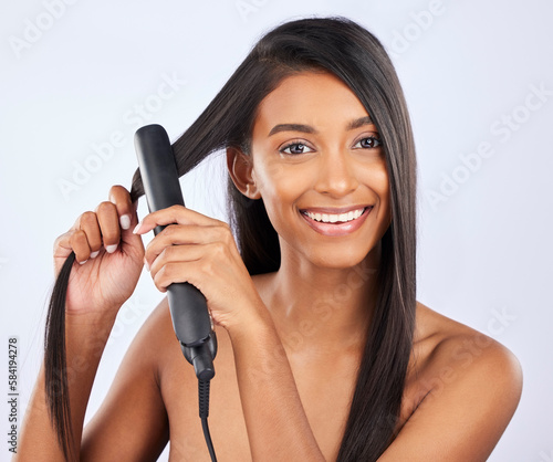 Portrait, happy woman or hair straightener in studio for beauty self care or style treatment on white background. Smile or face of Indian girl model or salon equipment for ironing in grooming routine