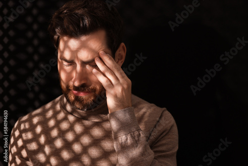 Upset man listening to priest during confession in booth, space for text © New Africa