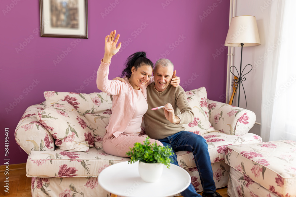 Mature couple feeling happy after taking a home pregnancy test. Artificial insemination, menopause. Mature couple feeling happy after taking a home pregnancy test. Artificial insemination, menopause.