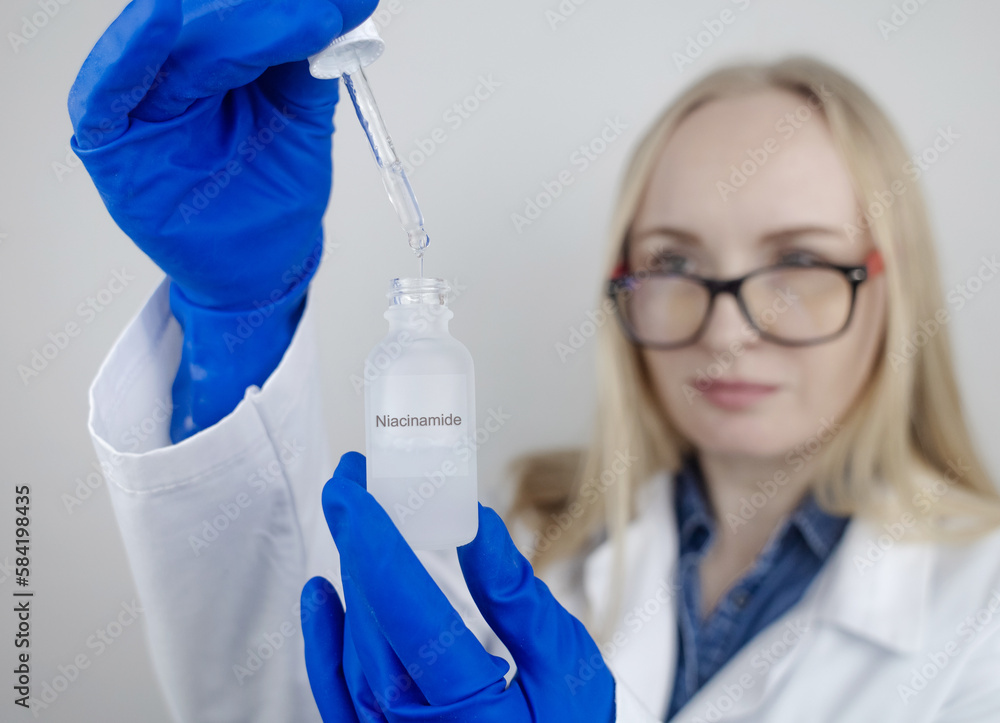 Niacinamide. Girl applies vitamin b3 to her face. Laboratory research