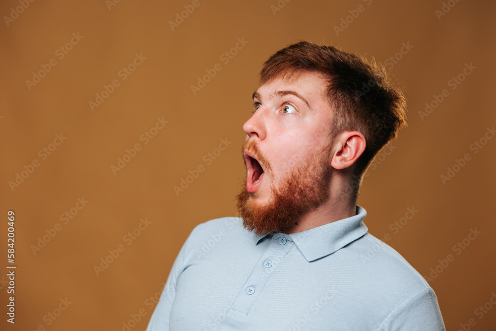 teenage guy looks surprised and amazed as he strikes a pose in front of the camera in a studio teenage guy looks surprised and amazed as he strikes a pose in front of the camera in a studio