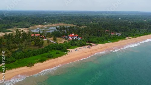 Aerial view from above of the tropical sandy beach with the hotel. Calm beautiful video on the background for tourism, design and advertising.