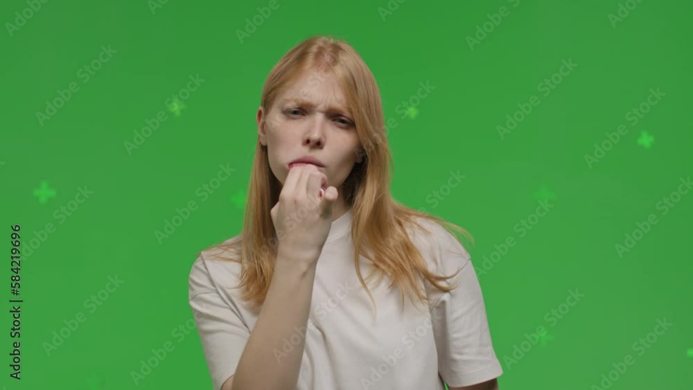 Attractive young redhead woman brushing her teeth with a toothbrush on a green background. white race girl take care of oral cavity. Female swipes finger at virtual display of phone Attractive young redhead woman brushing her teeth with a toothbrush on a green background. white race girl take care of oral cavity. Female swipes finger at virtual display of phone