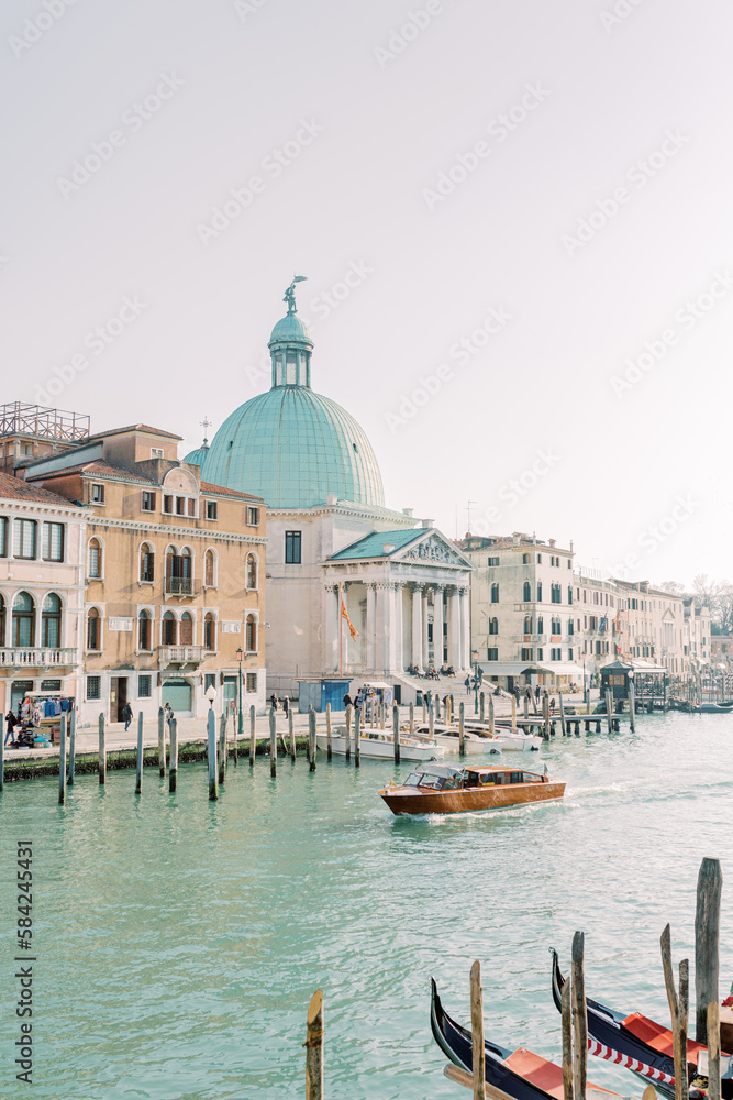 By boat across the turquoise waters along the Venice coast. The bright stones of the walls reflect the sun