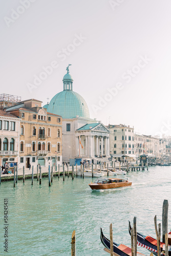 By boat across the turquoise waters along the Venice coast. The bright stones of the walls reflect the sun