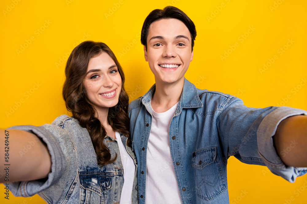 Portrait of two positive nice partners toothy smile make selfie record video isolated on yellow color background Portrait of two positive nice partners toothy smile make selfie record video isolated on yellow color background