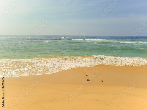 Beautiful sand beach and turquoise water. Summer holiday beach background. Ocean waves on empty tropical sand beach. Vertical background © acidmit