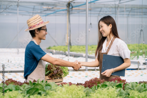 hydroponic salad vegetable garden owner shakes hands with the farmer after successful business cooperation.