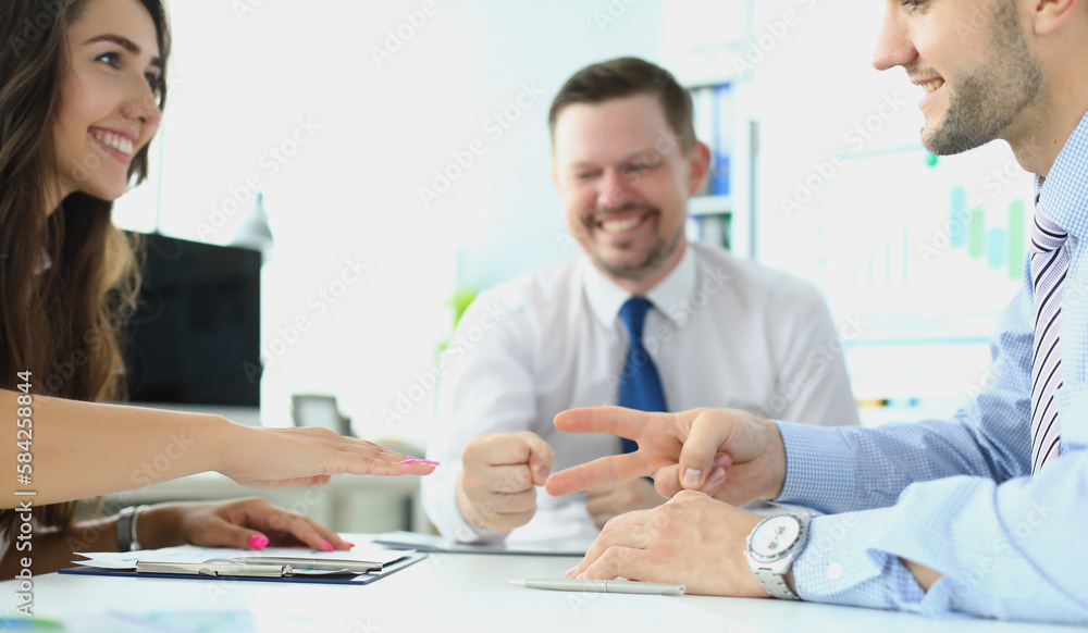 Caucasian businessman and businesswoman playing Rock Paper Scissors with business people Caucasian businessman and businesswoman playing Rock Paper Scissors with business people
