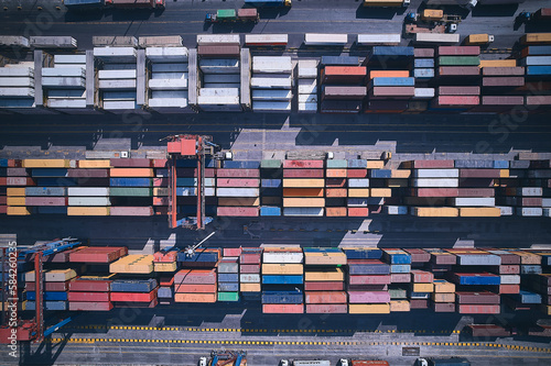 Stacked cargo containers top down aerial view. Containers at logistics terminal. Cargo container outdoor warehouse