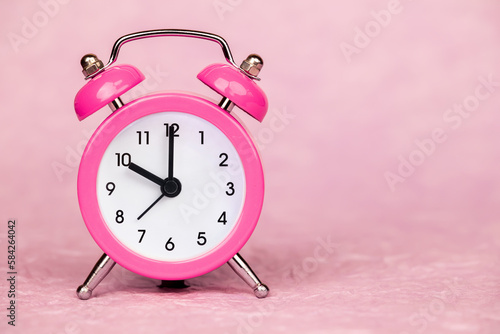 Pink retro alarm clock. Daylight savings time or happy morning background with copy space