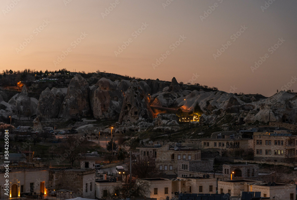 Sunset landscape of Cappadocia town with lights and houses, Turkey