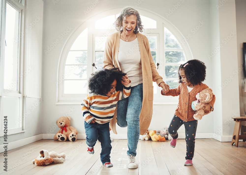 Hopscotch, grandmother and children play in home having fun, enjoy games and balance together in bedroom. Happy family, entertainment and grandma with kids for jumping, playing and numbers activity Hopscotch, grandmother and children play in home having fun, enjoy games and balance together in bedroom. Happy family, entertainment and grandma with kids for jumping, playing and numbers activity