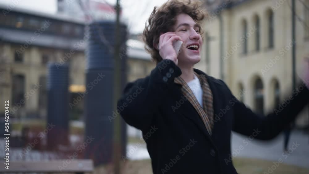 Portrait of happy man talking on phone as live camera zoom in. Satisfied confident positive Caucasian guy standing on street in urban city smiling chatting Portrait of happy man talking on phone as live camera zoom in. Satisfied confident positive Caucasian guy standing on street in urban city smiling chatting