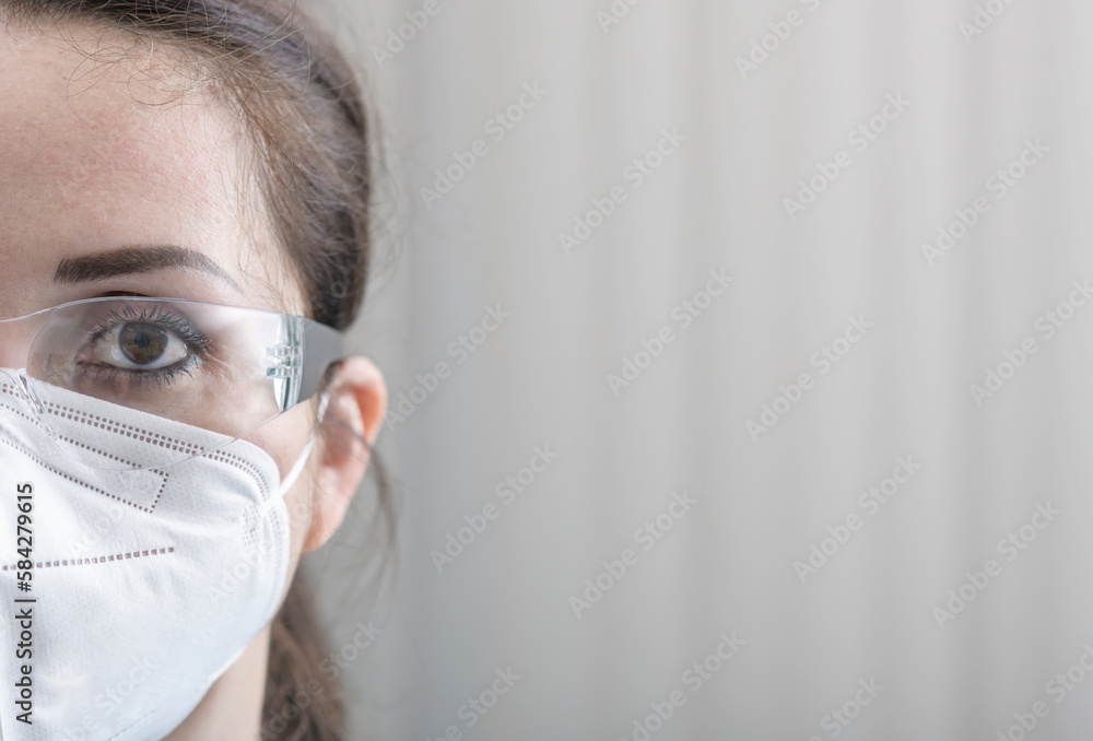 Nurse's close-up half face protrait with protective glasses and N95 mask Nurse's close-up half face protrait with protective glasses and N95 mask