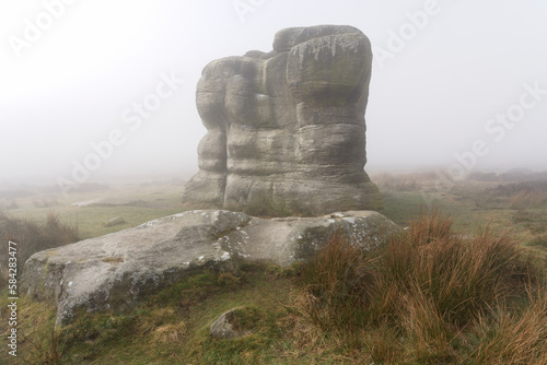 Thick fog surrounds the Eagle Stone on Eagle Stone flat, Baslow Edge, Derbyshire.