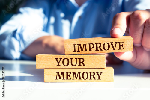 Close up on businessman holding a wooden block with "Improve Your Memory" message