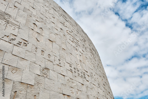 The Bibliotheca Alexandrina or Library of Alexandria is a major library and cultural center on the Mediterranean shore in Alexandria, Egypt. Ancient Egyptian hieroglyphs on the facade against sky photo