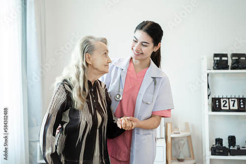 Professional helpful caregiver comforting senior woman at nursing home,Senior services and geriatric care concept.