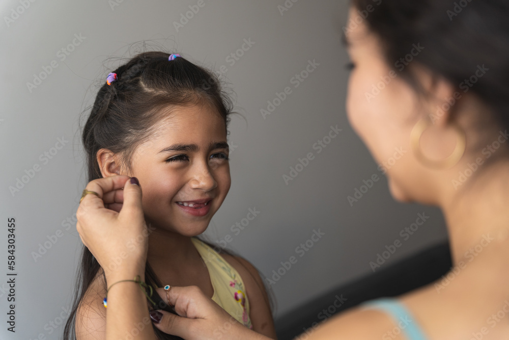 mother caresses her girl's face while they both smile mother caresses her girl's face while they both smile