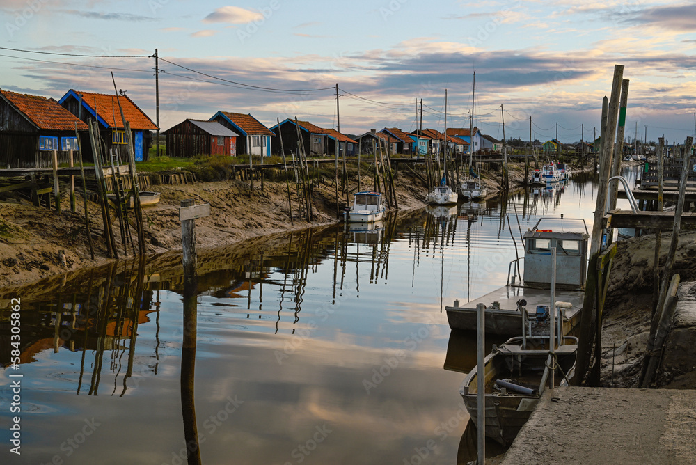 The port of La Tremblade is a major center for refining oysters and is located near the Seudre River. We can see the boats used in the oyster parks. This photo was taken at sunset.