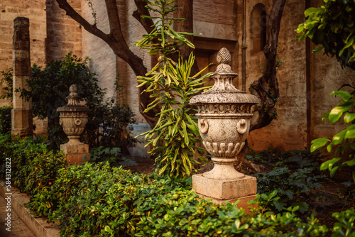 Ancient decorative vases in the garden next old town. Blurred building in the background. Valencia, Spain