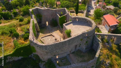 This aerial stock video captures the stunning ruins of the Old Bar or Stari Bar, a historical landmark in Montenegro. The drone footage showcases a bird's eye view of a stone fortress and an aqueduct photo