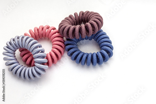 twist or invisible hair ties isolated on white in pastel colors.