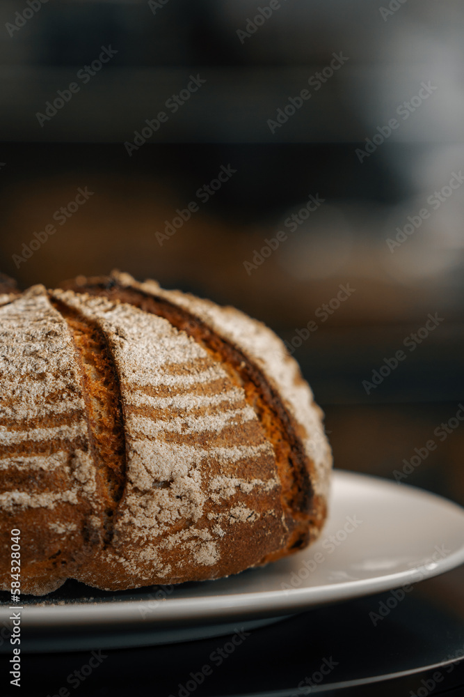 Close-up, bakery - freshly baked dark bread on a rotating surface