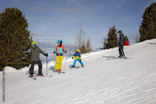 Happy family, enjoying ski holiday with children, sunny beautiful weather