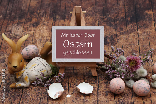 Osterdekoration mit dem Text Wir haben über Ostern geschlossen auf einer Staffelei.