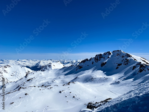 Alpine valley, snowy mountains in Switzerland. Panoramic view over the mountains during winter. Ski area Arosa, Lenzerheide in Switzerland. Winter sports in the snowy mountains.