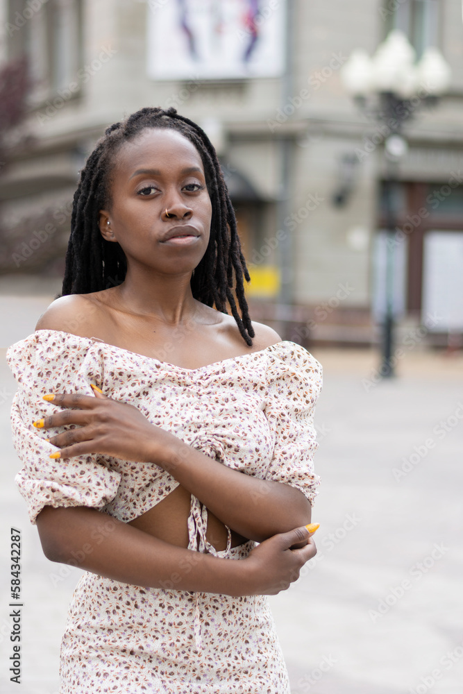 Portrait of a black confident woman unfocused on the street of the city in the day of summer. Concept: dating, falling in love, searching for dates, mental health, self-determination, personality Portrait of a black confident woman unfocused on the street of the city in the day of summer. Concept: dating, falling in love, searching for dates, mental health, self-determination, personality