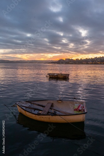 Vertical shot of the boats in the sea at sunset