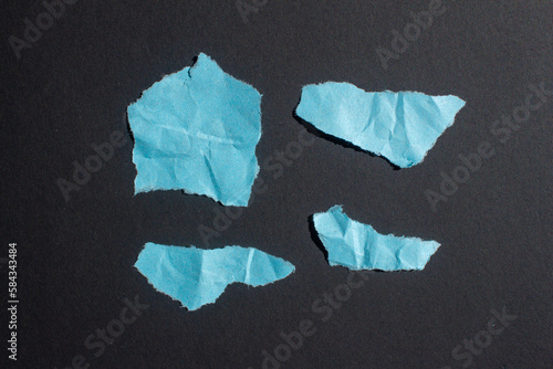 Set of wrinkled blue paper pieces on a black background. Ripped paper.